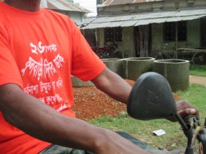Of course not everybody in Phulbari is in the rally to the martyrs monument as some of them are busy doing farming or other businesses. This tractor driver is driving his vehicle to the opposition direction of the monument but is expressing his solidarity to the rally by wearing a t-shirt. The slogan says: "Stand against all conspiracy to establish the destructive open pit coal mine."   