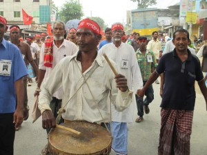 A santal man plays his dhol in the rally. 